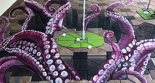 Posing playing golf on 3D putting green with octopus tentacles street painting